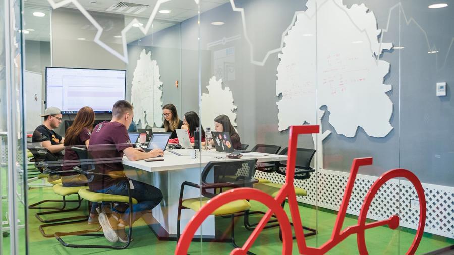 a group of people sitting at a table with computers